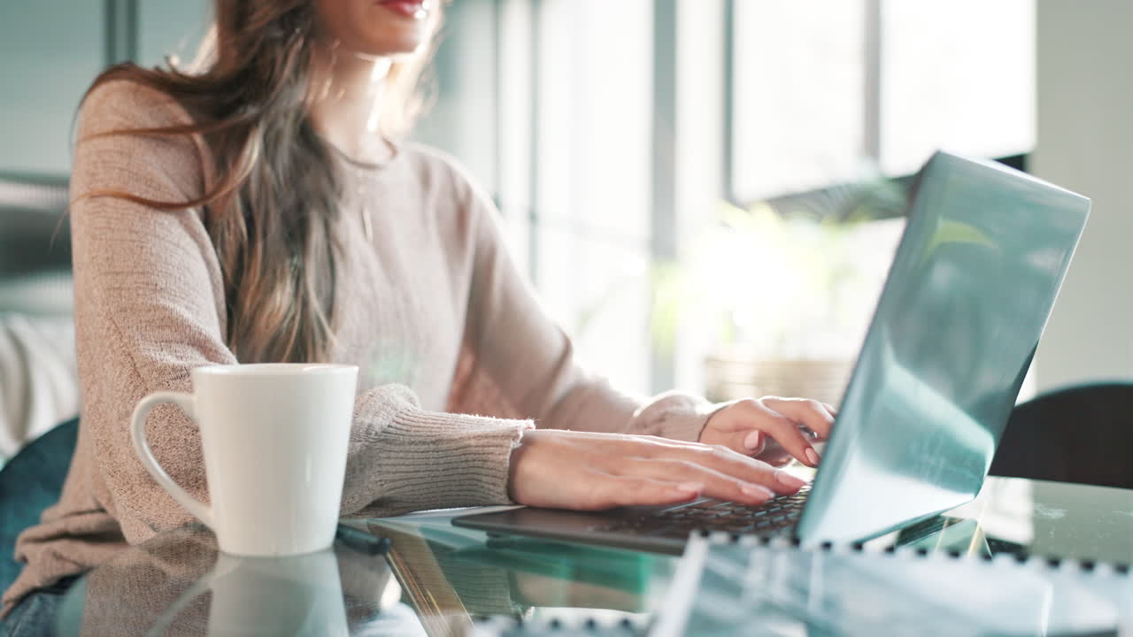 Woman working on laptop with coffee