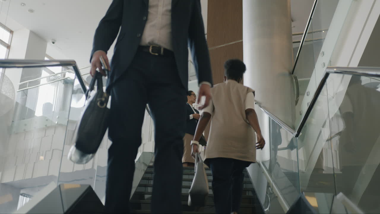 Businesspeople Walking Upstairs in a Modern Hotel Lobby