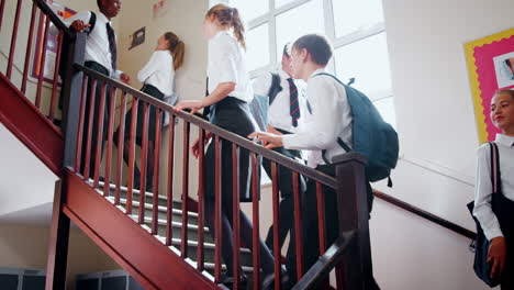 Teenage-Students-In-Uniform-Walking-Down-Stairs-Between-Lessons