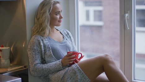 Woman-with-mug-looking-out-window