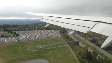vista del ala del avión sobre la ciudad y la carretera