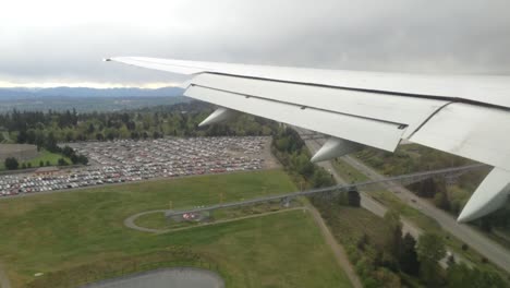 airplane wing view over city and highway