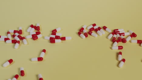 Slow-motion-high-angle-medium-shot-as-a-handful-of-pills-fall-vertically