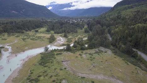 rising tidal flat aerial reveals town of bella coola in distant valley