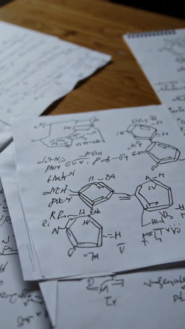 handwritten notes and chemical structures on papers