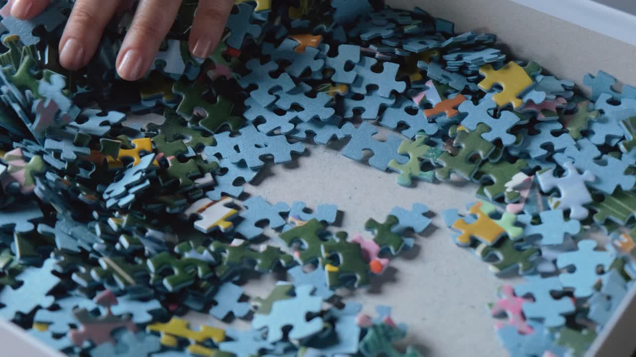 mano de mujer navegando a través de piezas de juego de rompecabezas de colores a cámara lenta 50i