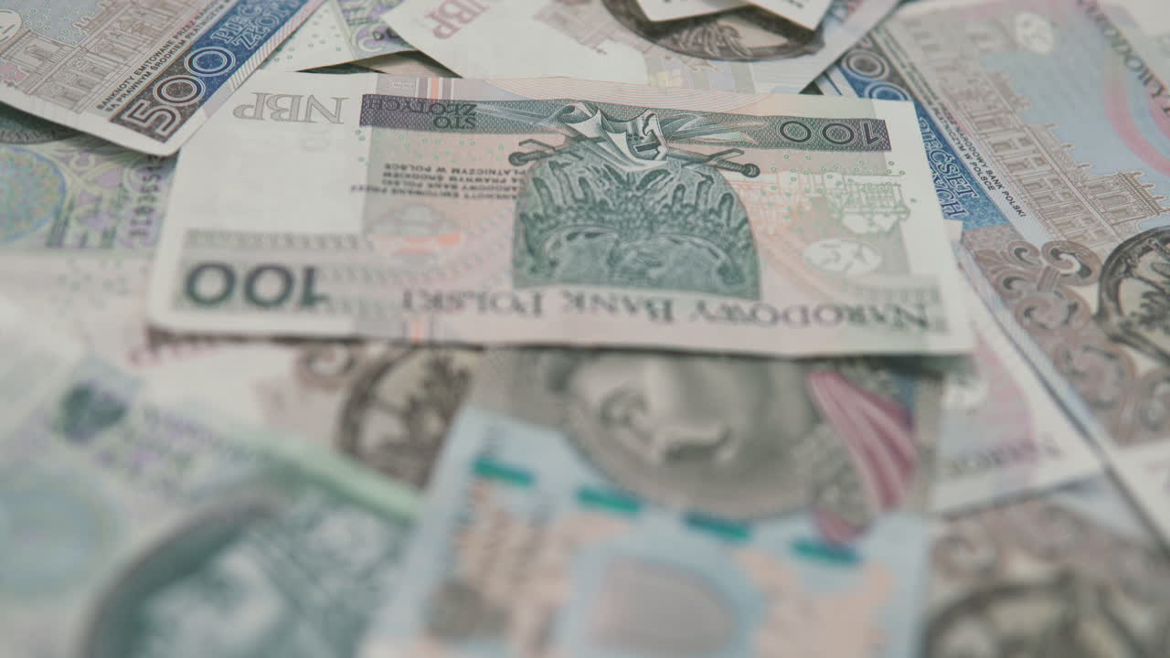 inclinación: tomando el enfoque en el dinero sobre la mesa, fondo con mucho dinero: 500 y 100 pln