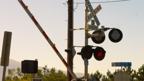 railway tracks arm raises after a train has passed and the lights are flashing