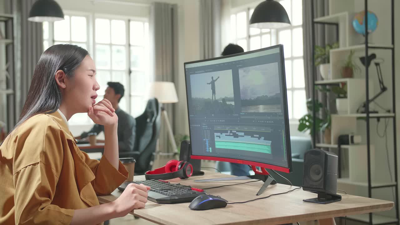 Asian Female Video Editor Paining Her Back While Works With Footage And Sound On Her Personal Computer In Office
