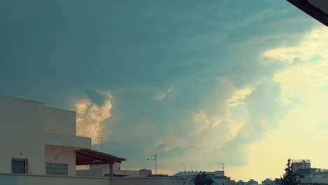 dramatic moving colorful clouds, blue and yellow sky, building rooftop, time lapse, 4k video