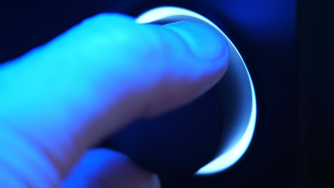 어 속에서 손은 볼 컨트롤을 돌리고, 파란 빛으로 조명됩니다.