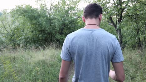 young man walking in the forest, summer time