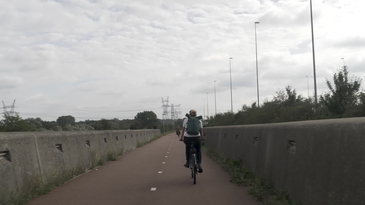 도시 지역을 통과하여 자전거 길을 따라 자전거를 타는 젊은 여성