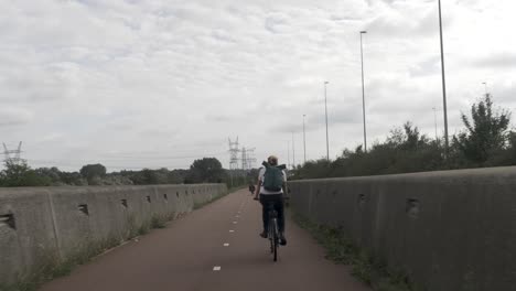 A-Young-Woman-Cycling-on-a-Bike-Path,-Through-an-Urban-Area