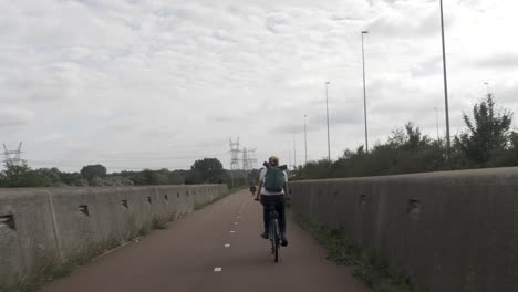 a young woman cycling on a bike path, through an urban area