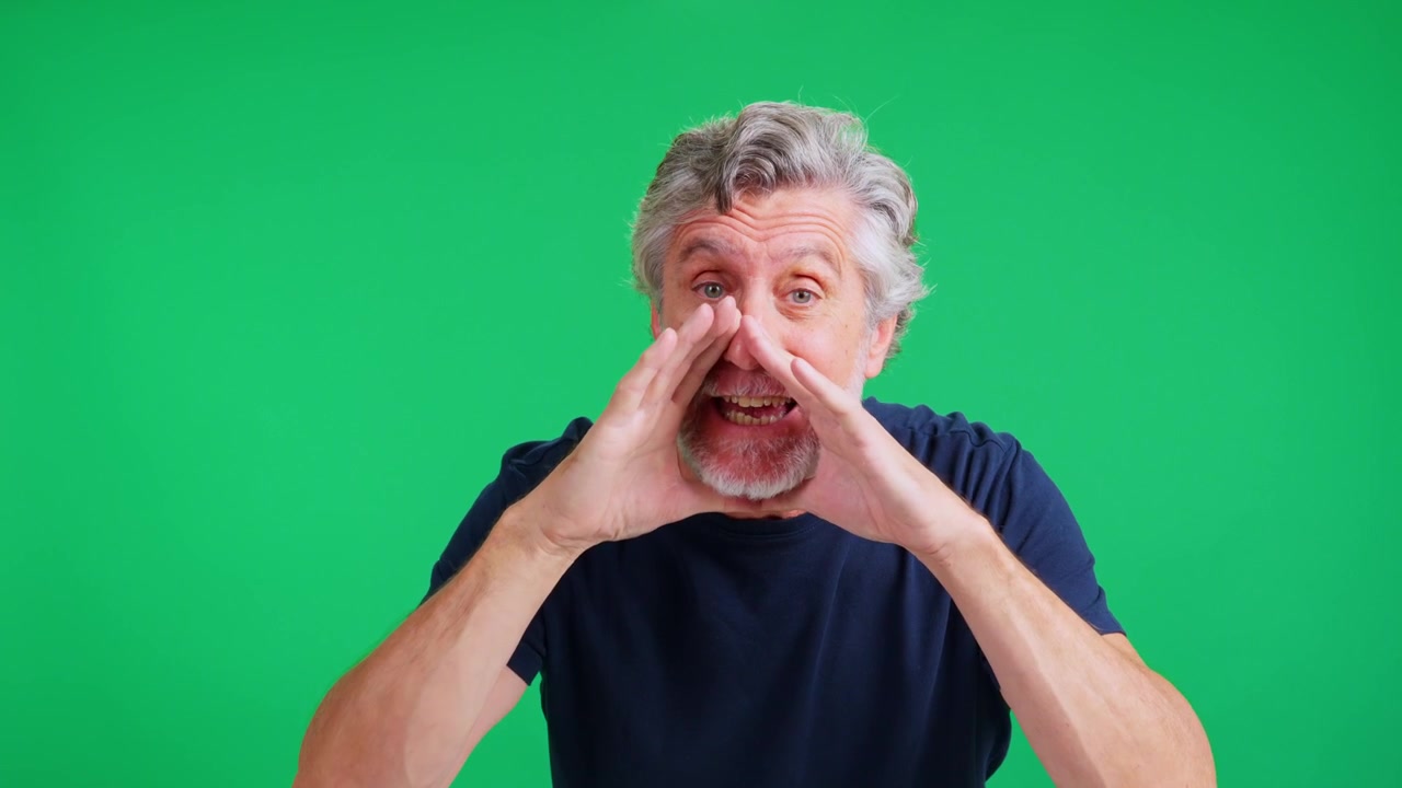 Uomo maturo che urla un messaggio su schermo verde.