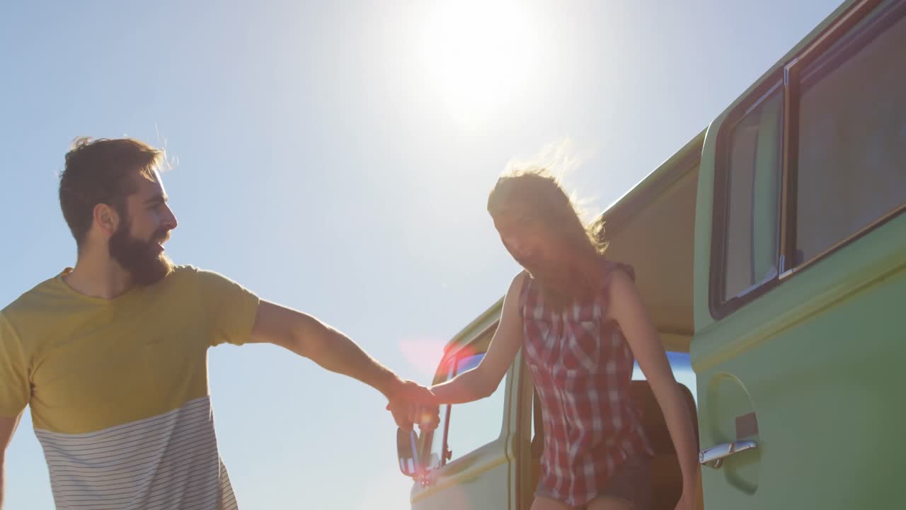 행복한 젊은 커플이 손을 잡고 밴 4k에서 나온다.