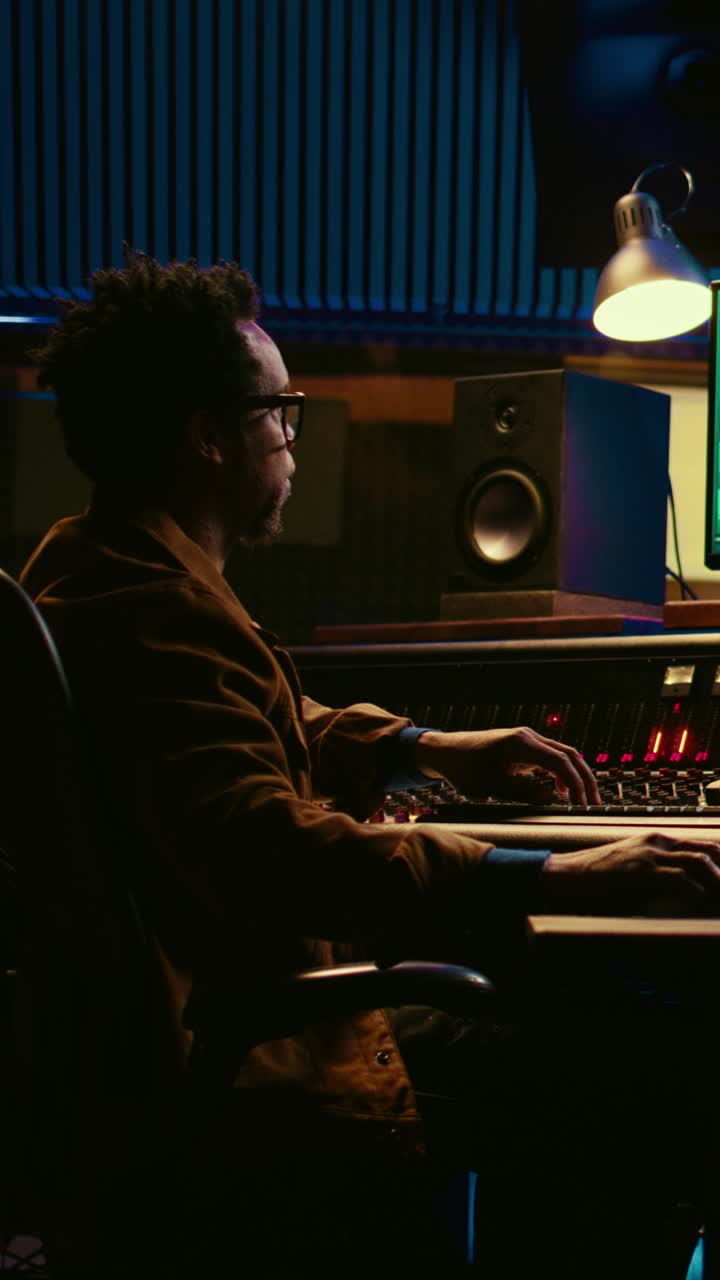 Man Working on Sound Mixer and Keyboard in Music Studio