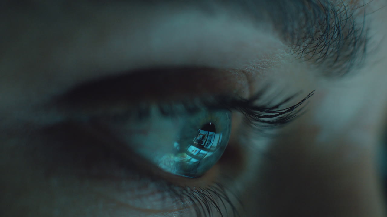 occhio macro guardando lo schermo del tablet navigando sui social media di notte concetto di dipendenza