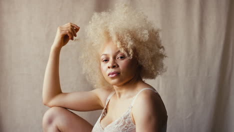 portrait en studio d'une femme albino naturelle confiante en sous-vêtements promouvant la positivité du corps