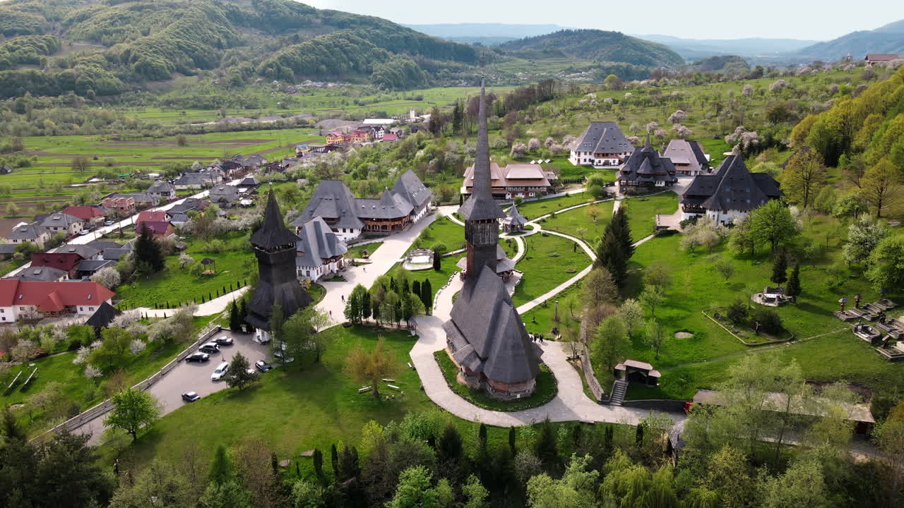 Vista aerea con drone del monastero di Barsana, Romania. Edifici, giardino con persone, colline circostanti coperte di foreste