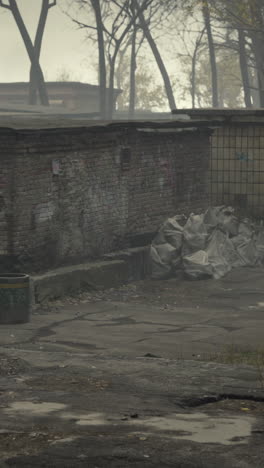 a gloomy view of an abandoned brick building in a foggy urban environment