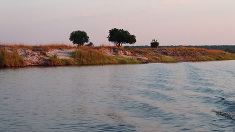 a boat cruise along the namibia side of the zambezi river in summer in the caprivi strip-zambezi region at sunset