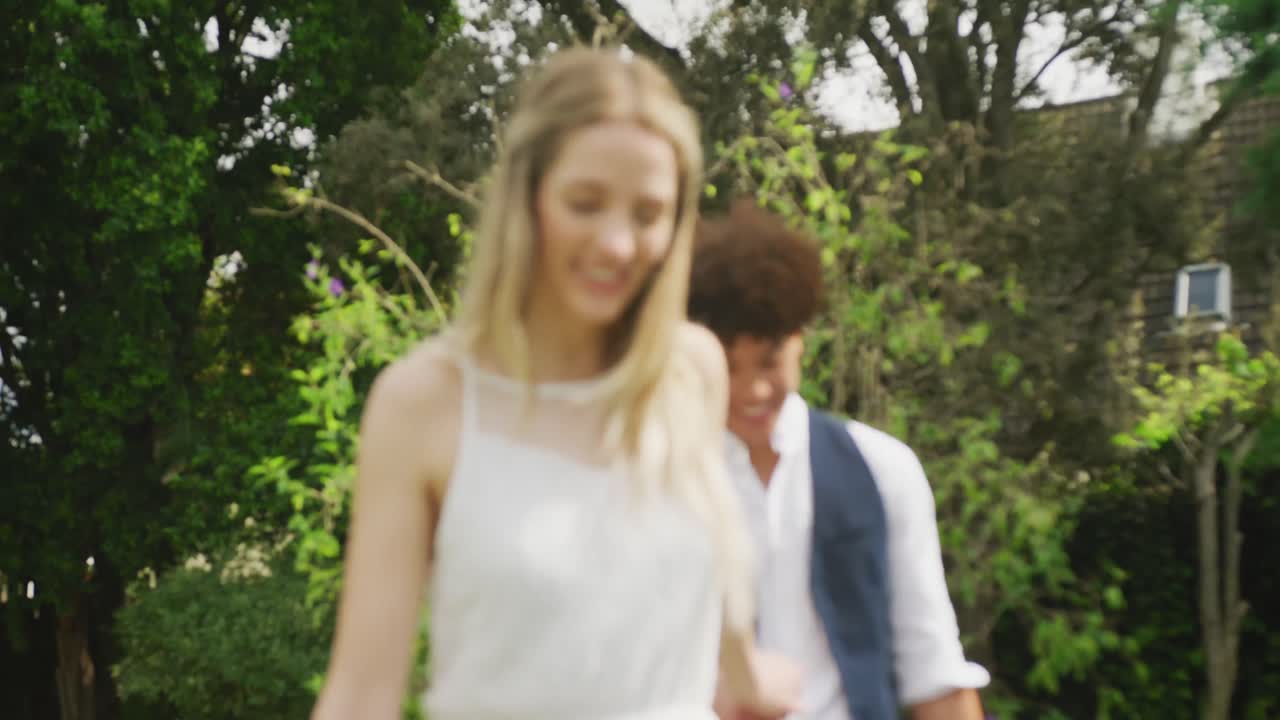 행복 한 다양한 커플 이 결혼식 에서  ⁇ 은 날 에 정원 에서  ⁇ 고 있다