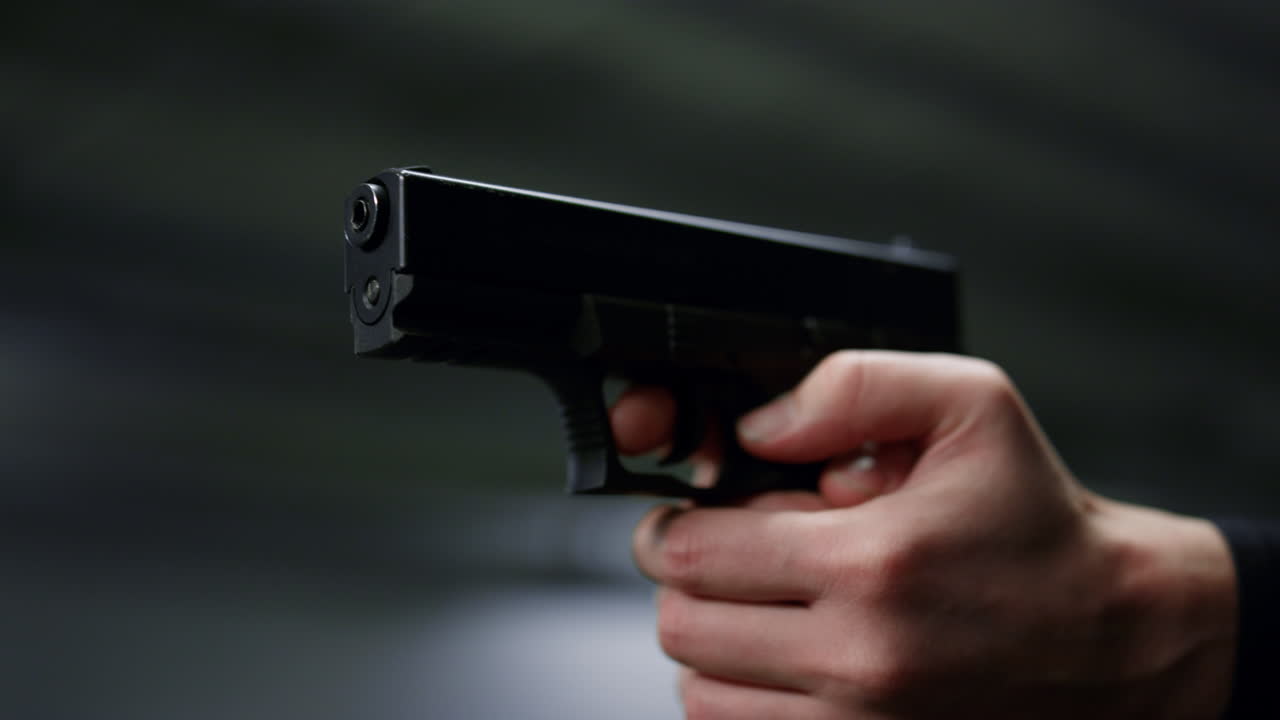 Male hands holding loaded gun. Policeman arms shooting with weapon