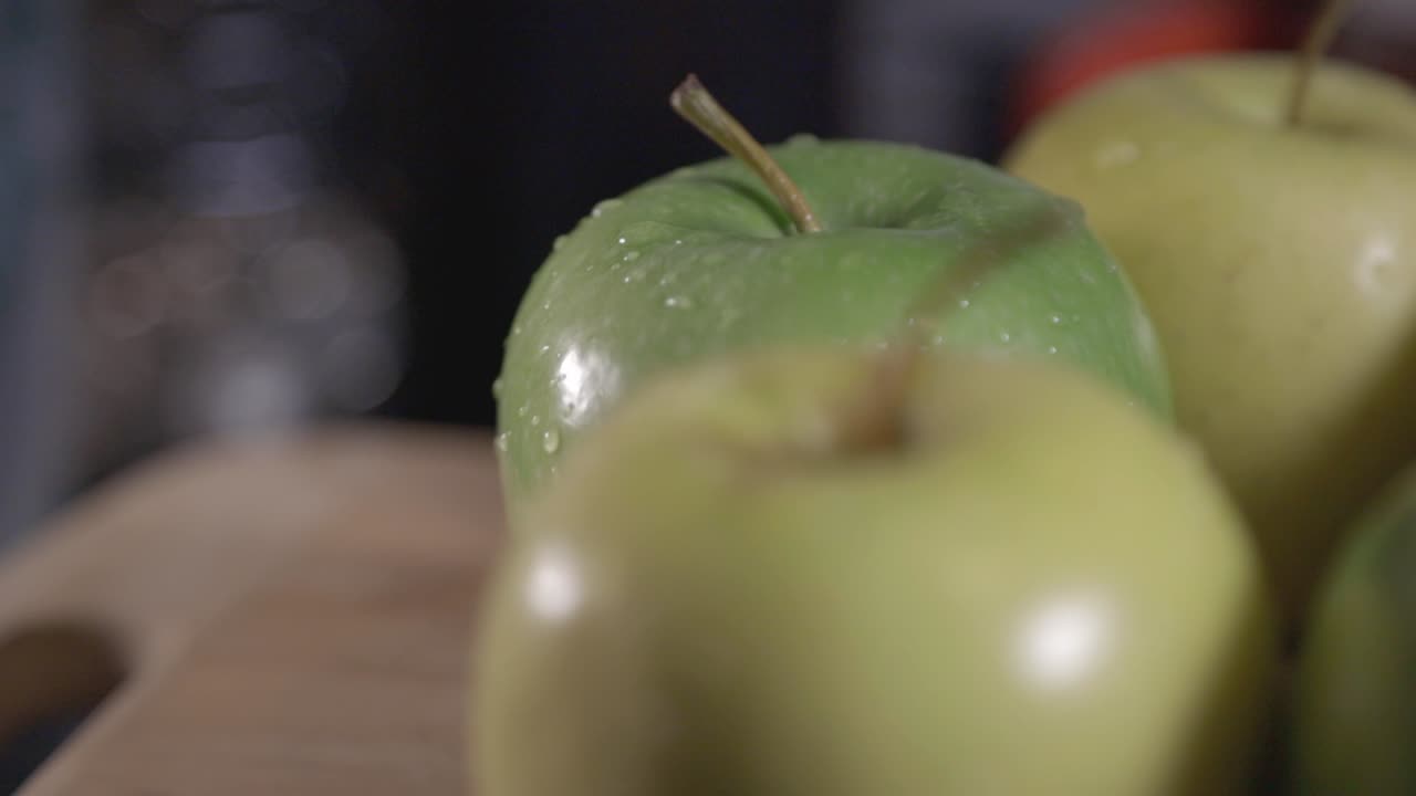 A Fresh Green And Yellow Apples With Water Drops On The Rotating Wooden Table - Closeup Shot