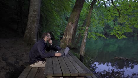 businessman sitting on the bench in the forest.