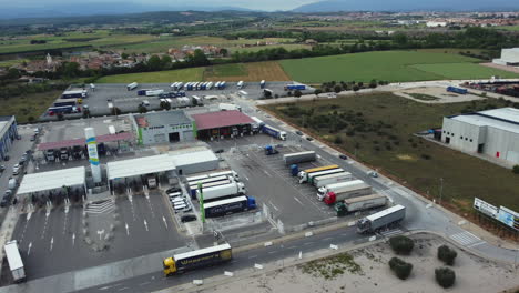 truck stop with parking lots and gas station - aerial view