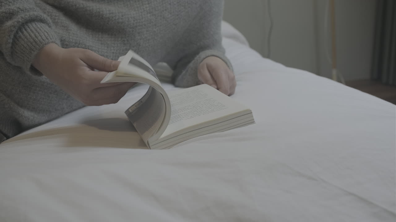 Person turn pages quickly and read superficially and leisurely lying on a bed. Close up shot