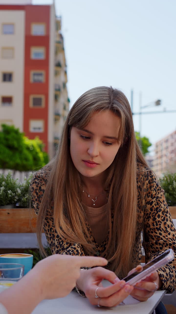 Young women chatting at an outdoor cafe