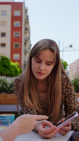 young women chatting at an outdoor cafe