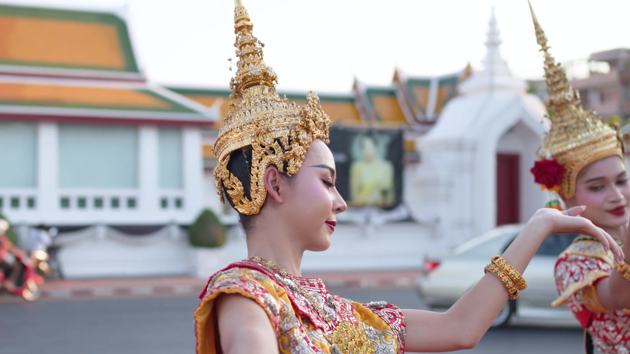 Danzatori tradizionali thailandesi che si esibiscono davanti a un tempio di Bangkok