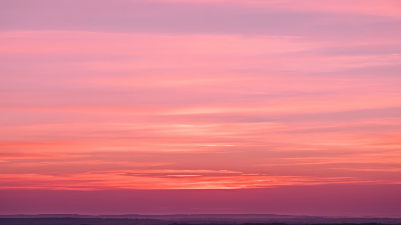 Cielo al tramonto rosa e arancione vibrante con nuvole in movimento