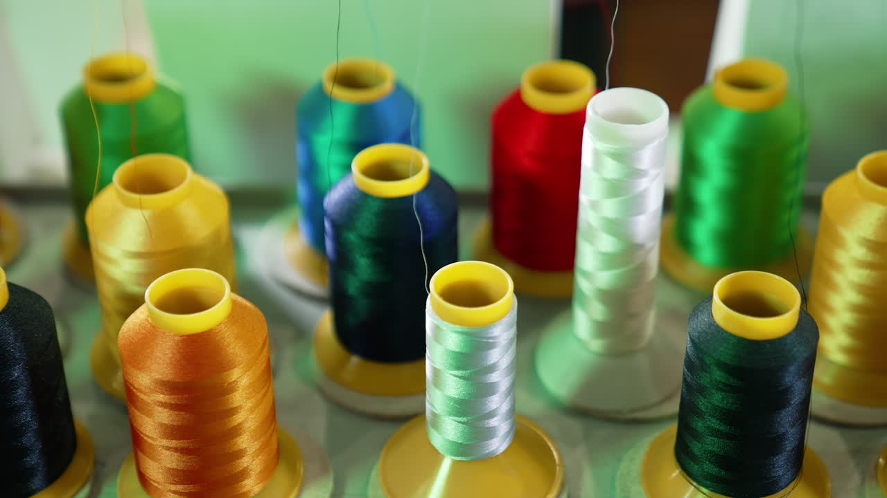 Threads in spools for dressmaker. Collection of colorful threads. Sewing tools. Background of colorful bobbins. Close-up. Hobbies and handicraft concept.