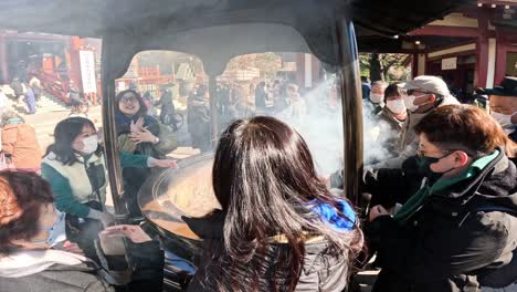 visitors participating in incense burning ritual