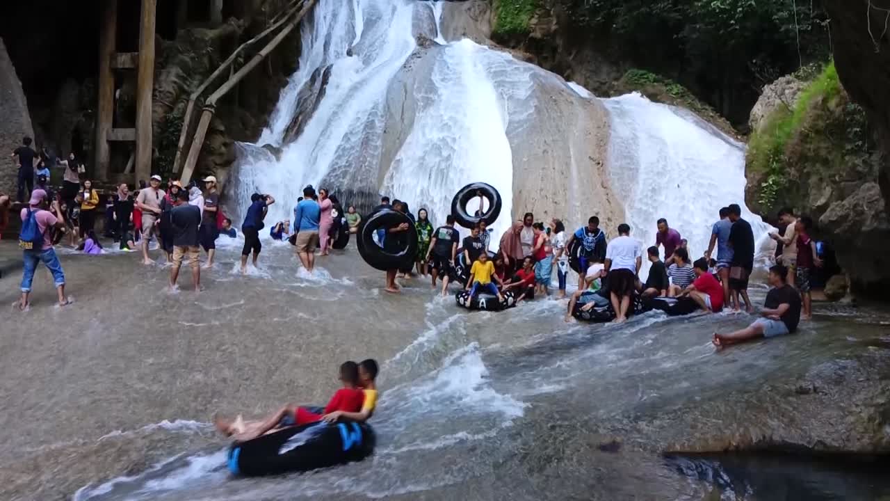 People enjoying a refreshing summer day at a beautiful waterfall