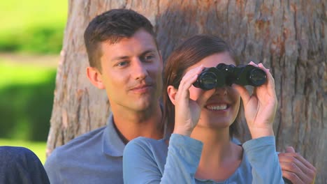 Young-couple-watching-something-through-binoculars