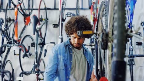 Mechanic-repairing-bicycle-in-workshop