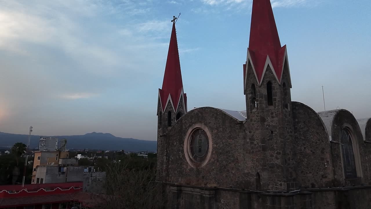 Parallax drone shot of Calvary's Church bell tower at sunset in Cuernavaca, Morelos, Mexico