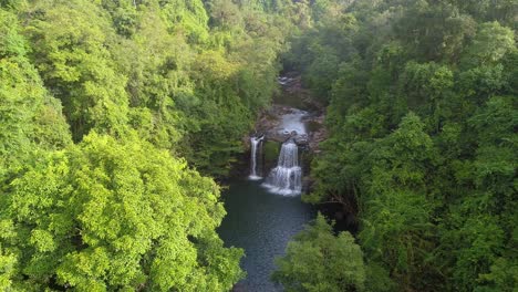 aerial view of a lush waterfall in a tropical rainforest