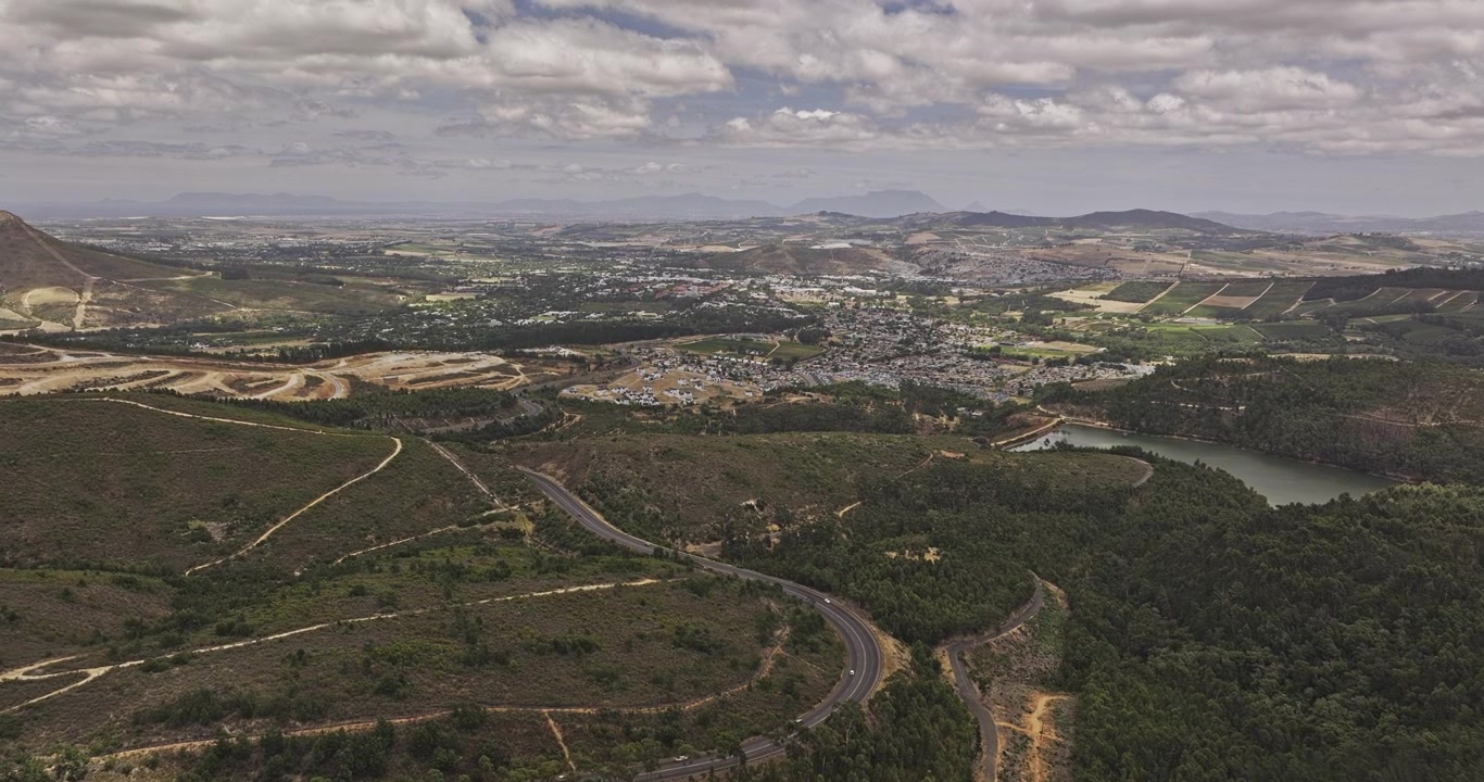 Stellenbosch, África do Sul - Sobrevoo Aéreo v8 acima da Estrada Helshoogte e da Barragem Idasvallei em direção a residências na encosta e paisagem urbana montanhosa - Filmado com Mavic 3 Pro Cine - 6 de janeiro de 2024