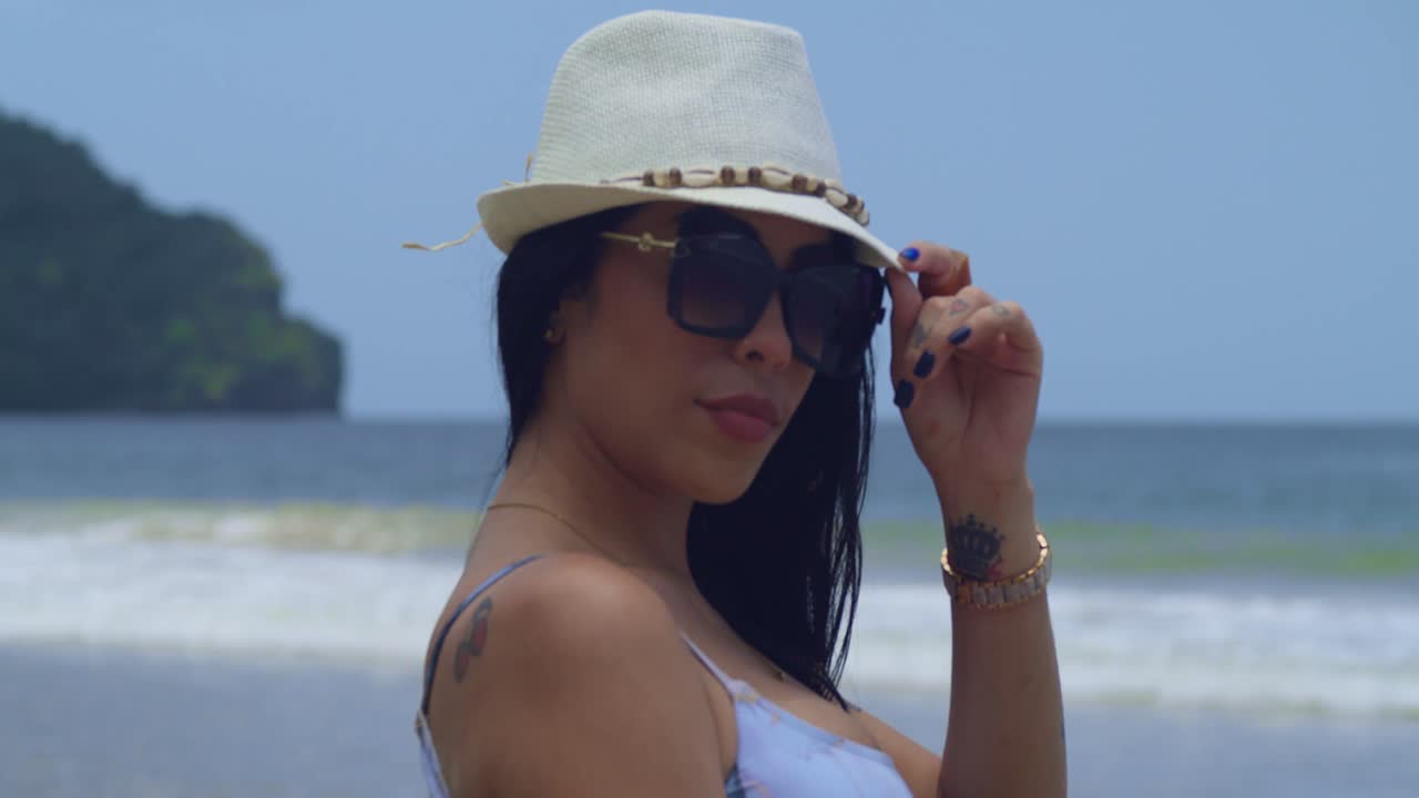 Trên bãi biển Caribe, một cô gái Latinh mặc bikini đang tận hưởng một ngày nắng đẹp, cận cảnh khuôn mặt