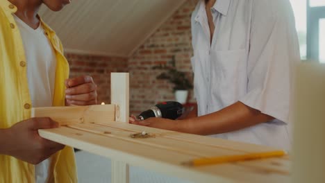 dos personas montando muebles de madera