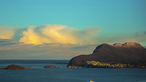tiro de lapso de tiempo del banco de nubes iluminadas al amanecer moviéndose a la derecha sobre el horizonte con tráfico de barcos en el fiordo en primer plano - alesund, noruega