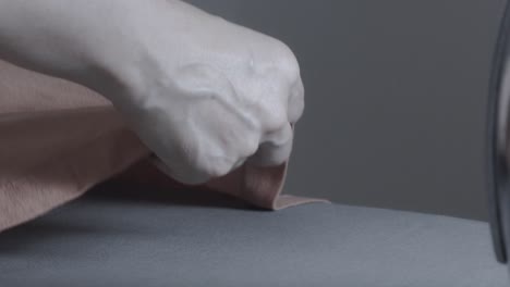 ironing wrinkled fabric in a textile factory - close up