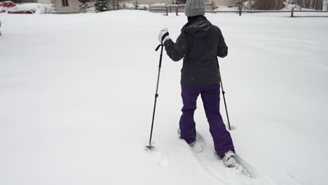 slow motion of female walking on snow with snowshoes in winter scenery of ouray, colorado usa